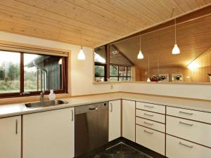 瓦伊厄斯斯特兰德8 person holiday home in Vejers Strand的厨房配有白色橱柜、水槽和窗户。