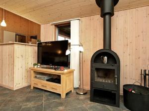 瓦伊厄斯斯特兰德8 person holiday home in Vejers Strand的客厅设有壁炉、电视和炉灶