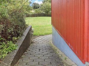 诺德堡30 person holiday home in Nordborg的红墙旁的砖砌走道