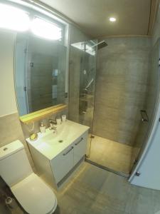 卢甘维尔Aore Breeze的浴室配有白色水槽和淋浴。