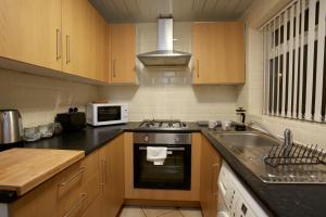 利兹Spacious Stylish Residence的厨房配有水槽、炉灶和微波炉
