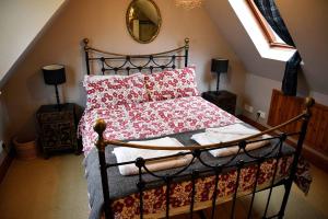 斯塔芬The Old Inn, Staffin的一间卧室配有一张带红色枕头和镜子的床