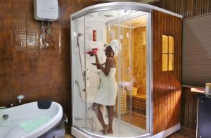 AnochiMaaha Beach Resort的站在浴室淋浴的女人
