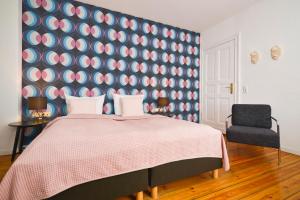柏林老城区酒店 的一间卧室设有一张大床和蓝色粉红色的墙壁。