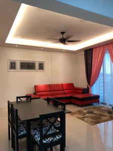 怡保KJ Homestay Casa Kayangan的客厅配有红色的沙发和桌子