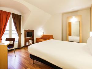 凡尔赛凡尔赛宫宜必思酒店 的酒店客房带一张大床和一把椅子
