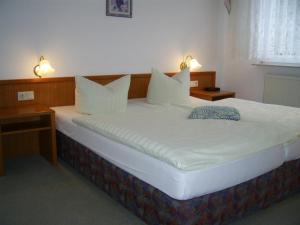 萨兰德特基什内尔酒店的一张配有白色床单和枕头的大床