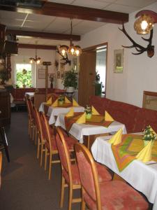 萨兰德特基什内尔酒店的用餐室配有桌椅和黄色餐巾