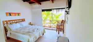 BocapánPalo Santo Beach club的一间卧室设有一张床和一个大窗户
