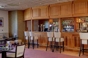 圣赫利尔泽西The Monterey Hotel - Sure Hotel Collection by Best Western的餐厅内的酒吧配有白色的桌椅