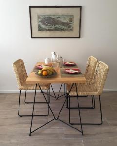 布宜诺斯艾利斯Moderno apartamento en excelente ubicación的一张木桌,配有两把椅子和一碗水果