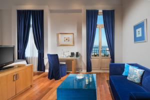 海若克利欧GDM Megaron, Historical Monument Hotel的客厅配有蓝色的沙发和桌子