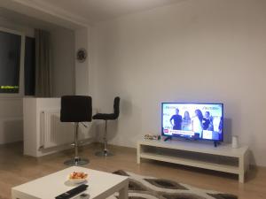 蒂米什瓦拉Take Timisoara Apartment的客厅配有餐桌上的平面电视