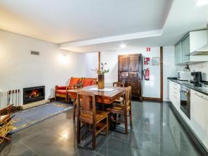 维尼艾什Casa da Mencha的厨房配有桌椅和壁炉。