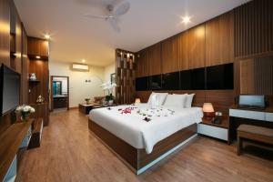 宁平Tam Coc Holiday Hotel & Villa的一间卧室配有一张带鲜花的大床