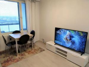 瓦萨Pro Apartments 2的客厅配有餐桌和平面电视。
