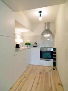 波尔图FLH Porto Modern Flat的铺有木地板的厨房配有白色家电