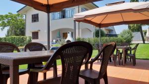 兰波雷基奥La Casa delle Rondini的一个带桌椅和遮阳伞的户外庭院。