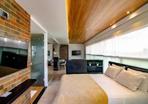 纳塔尔Reserva Madero Loft Natal Hotel的一间卧室设有一张大床和砖墙