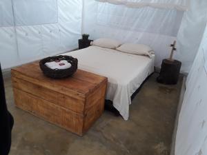 帕洛米诺El Nómada Hostel的一间卧室配有一张床和一张木桌