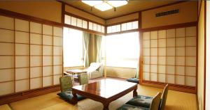涩川市伊香保银水酒店的客房设有桌椅和窗户。