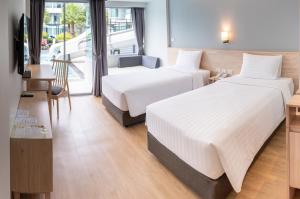七岩Bay Window at Sea的酒店客房设有两张床和一张桌子。
