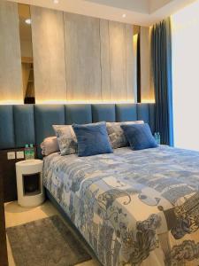 雅加达Gold Coast PIK Sea View Apartments by LongeSuites的一间卧室配有一张蓝色床头板的床
