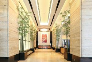 金泽KOKO HOTEL Premier Kanazawa Korinbo的带有盆栽植物的建筑走廊