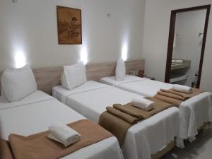 北茹阿泽鲁Hotel Padre Cícero的一间设有三张床的客房,备有毛巾