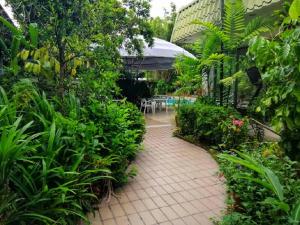 斯里巴加湾市特雷斯酒店的一个带砖砌走道和植物的花园