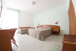 圣多米诺伊登酒店的一间卧室设有两张床、一张桌子和一个窗口