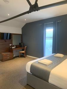 切斯特Oakwood Farm Mews Chester的一间卧室配有一张床、一张书桌和一个窗户。