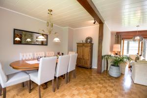 比特亨巴赫Ferienhaus Maison Idylle im Hohen Venn - Monschau的一间带桌子和白色椅子的用餐室