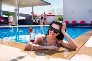 迪拜罗纳塔阿拉巴沙中心酒店的游泳池里的女人喝一杯葡萄酒