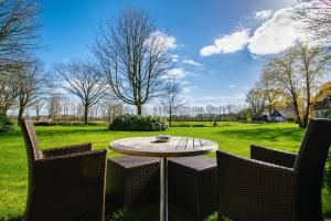 奥特马瑟姆帷幕赛尔公园酒店的庭院设有桌子、两把椅子和田野。