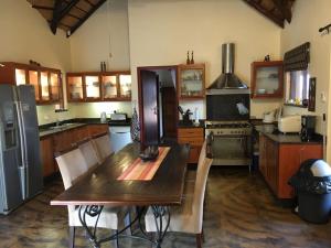 帕拉博鲁瓦Bushvilla Umoja Kruger的厨房配有木桌和冰箱。