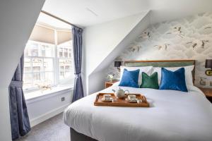 因弗内斯Blackfriars的一间卧室配有一张带蓝色和绿色枕头的床