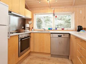 克兰尼茨Three-Bedroom Holiday home in Rødby 6的厨房配有木制橱柜和窗户。