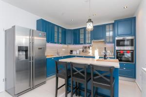 默克斯卡Villa Fortunei的厨房配有蓝色橱柜和不锈钢冰箱