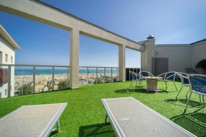 里米尼里米尼科拉洛酒店的阳台配有桌椅,享有海景。