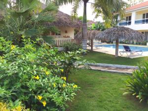 拉斯加勒拉斯Las Galeras Hotel的一个带游泳池和鲜花庭院的度假胜地