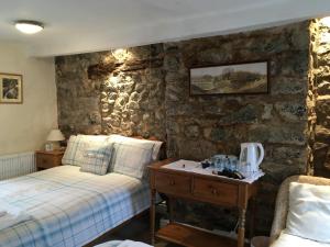 多尔盖罗Aber Cottage B&B的一间卧室设有两张床和石墙