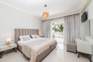 蒂锡利维Mamfredas Luxury Resort的白色卧室设有一张大床和电视。