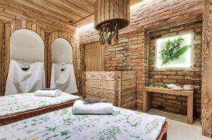 TrojanówTalaria Resort&Spa的一间卧室设有两张床和砖墙