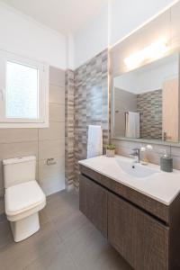 蒂锡利维Mamfredas Luxury Resort的一间带卫生间、水槽和镜子的浴室
