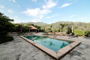 阿拉莫斯El Pedregal - Hotel en la Naturaleza的一座带庭院的游泳池,其背景是山脉
