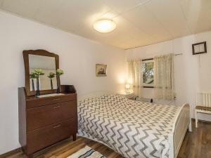 TallnäsHoliday Home Päivärinne by Interhome的一间卧室配有一张带梳妆台和镜子的床