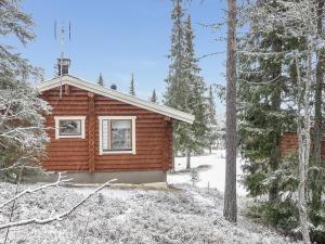 穆奥尼奥Holiday Home Oloskammi 5 by Interhome的地面上积雪的树林中的小木屋