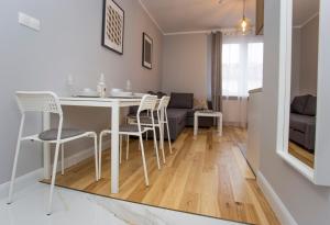 比亚韦斯托克CR Apartament w sercu miasta Lipowa 1的厨房以及带桌椅的起居室。