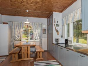 Tallnäs莱通涅米度假屋的厨房配有桌子、水槽和一些窗户